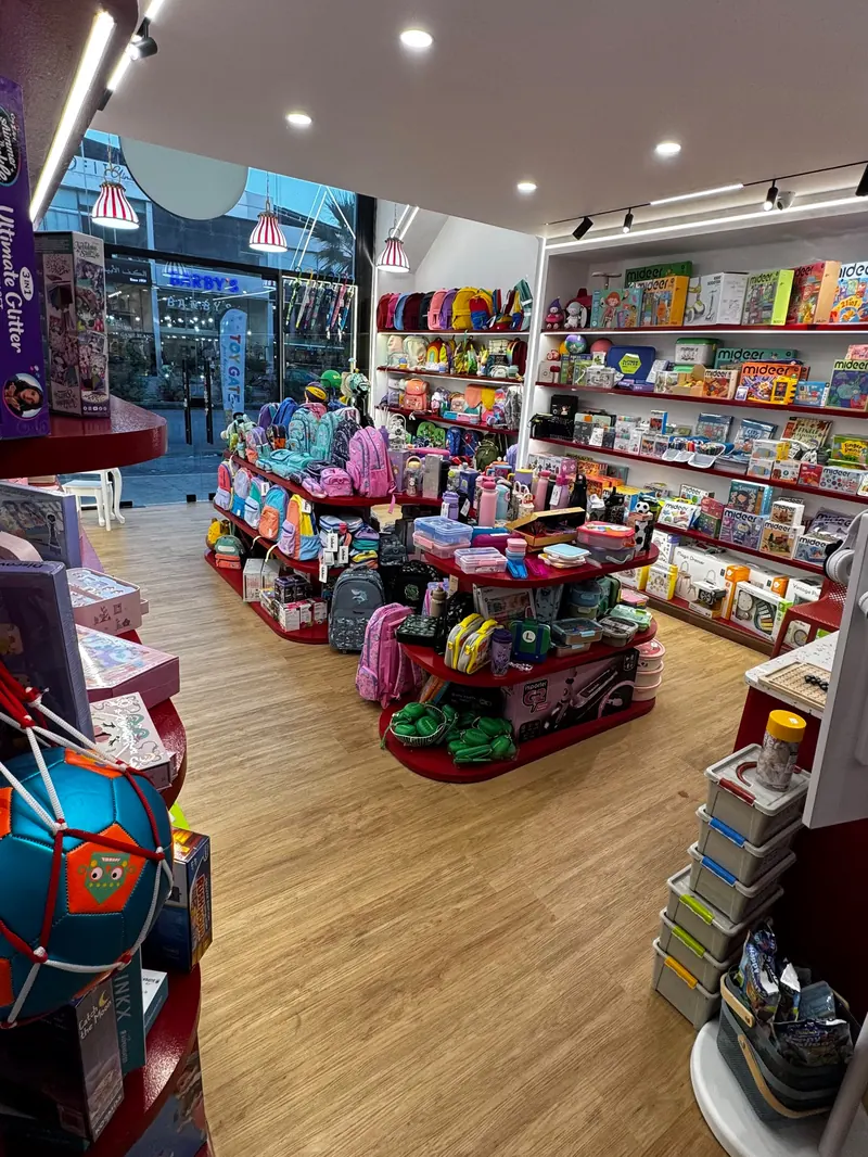 A view across the shop toward the glass front and the street, past the display islands and the wall shelves.